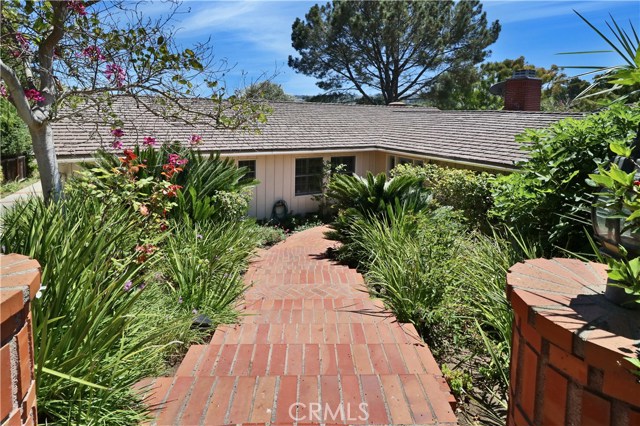 Street view of lush landscaping and steps leading to the Main Entry