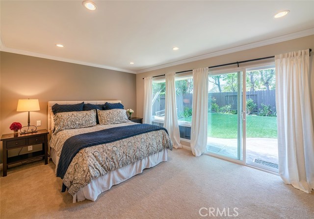 Master suite with doors leading to lower tier of the back yard.