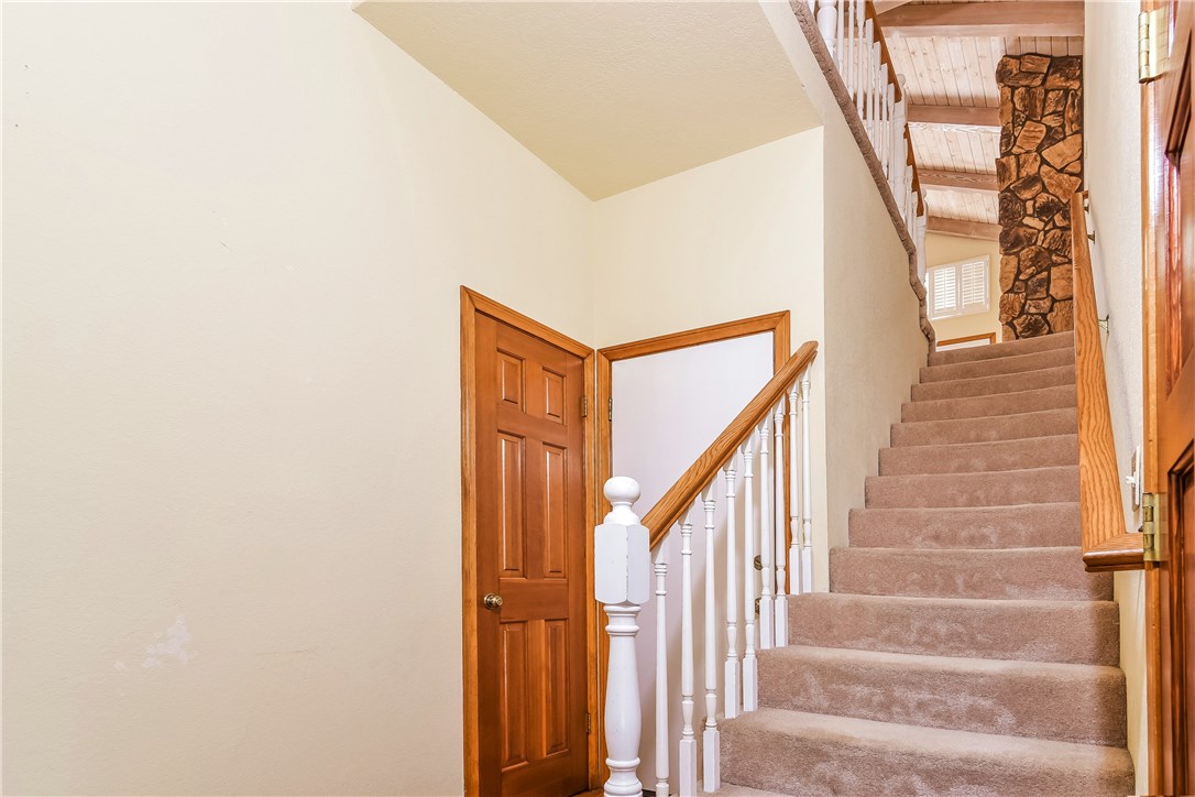 The entry stairway is wide with easy acces to the upper floor and the doors and molding are rich wood throughout the home.