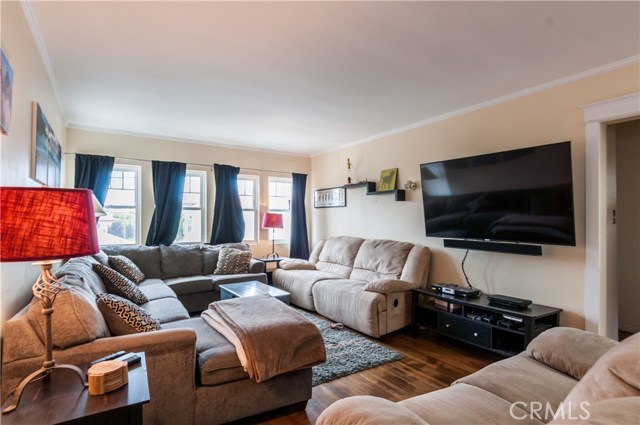 Large living room has lots of windows, oak hardwood floors and room for all these couches!