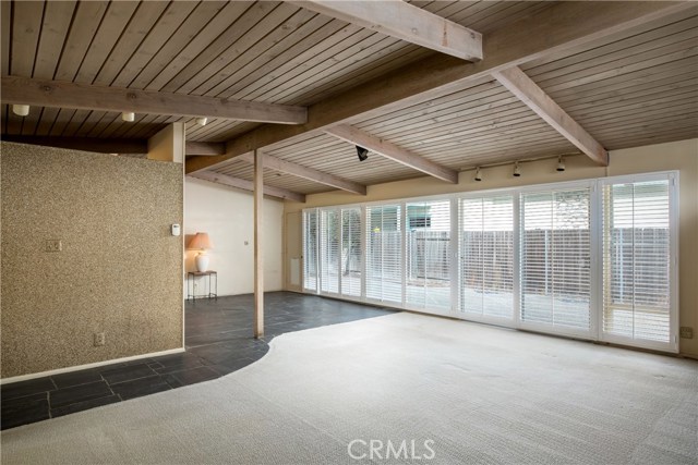 Living room and dining area facing huge side yard through wall of windows.