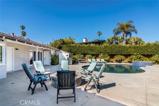 A resort of your very own - this gorgeous backyard offers a sparkling pool with spa, patios for lounging, outdoor dining area or courtyard and a fireplace as a focal point to create a stunning setting.