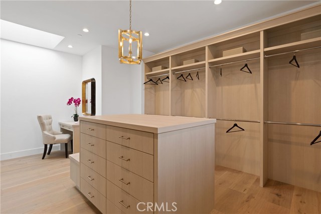 Master closet has a center island with side bench seating, locking, velvet lined jewlery drawers and an abundance of hanging space