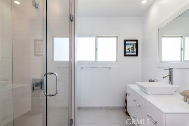 With tasteful touches found throughout, this full bath for the bedrooms spaces offers clean white cabinetry and a spacious shower.