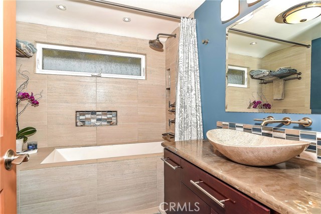 The remodeled 2nd bath has slab marble counters a raised pedestal bowl sink and quality fixtures