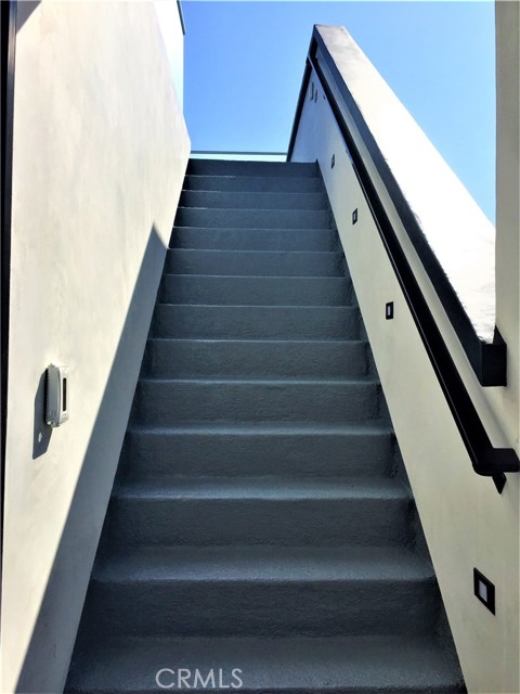 The Stairway leading to the roof deck has a Weather Resistant Surface, Lighting and  Metal Railing