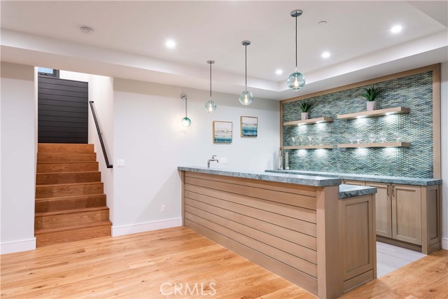 Amazing Finished Basement! 625 Square Feet- Can qualify as Bedroom #6. Leather Finish Custom Granite Countertops. Built In Refrigerator, Dishwasher and Sink with unique water tap. Beautiful Custom Glass Tile Backsplash, Framed. Floating Custom Shelving with Built In Under Shelf Lighting. Ample Cabinet and Storage Space. High Quality Lighting Fixtures with Dimmer Controls.