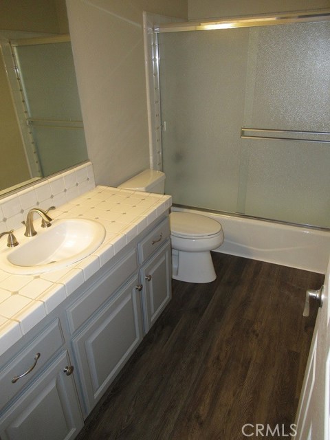 Upstairs Bath with refurbished and painted cabinets and new vinyl hardwood flooring.