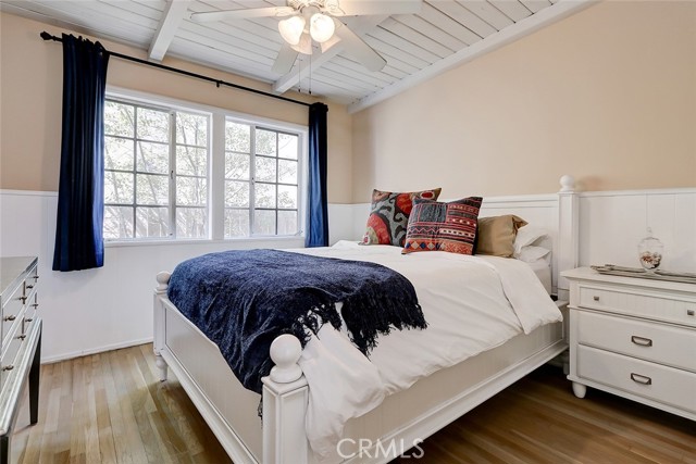 Secondary guest bedroom with vaulted ceilings and hardwood floors.