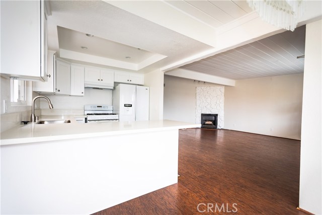 Spacious Living area with fireplace, beam ceilings and hardwood floors.