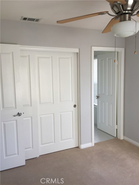 Upstairs bedroom with fan and ensuite bath.