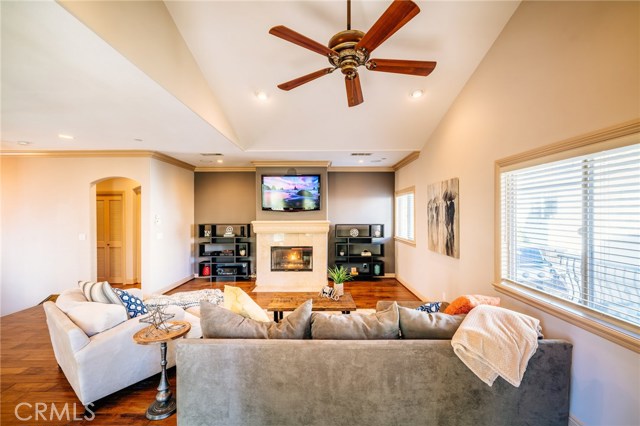 The view of the living room shows its tremendous appeal. A big open space, with the detail and character to give the home a dynamic look and feel. From the crown moldings to the centerpiece fireplace, to the  archway and vaulted ceilings, the room has form and function and feel very comfortable while being elegant and chic.