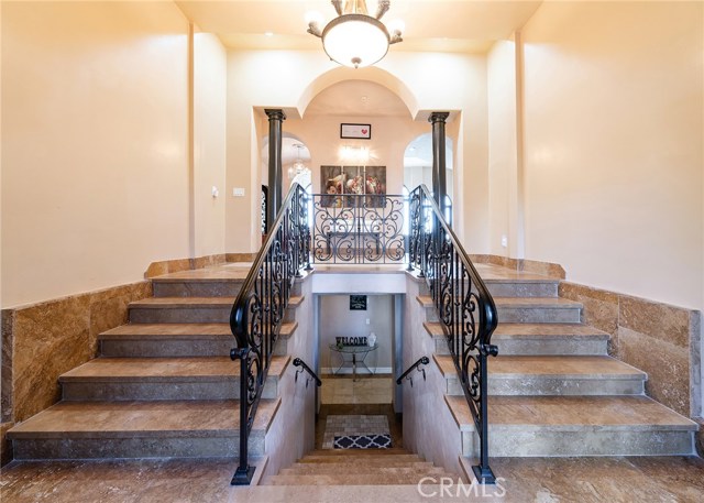 Impressive entry with natural stone flooring and custom railings