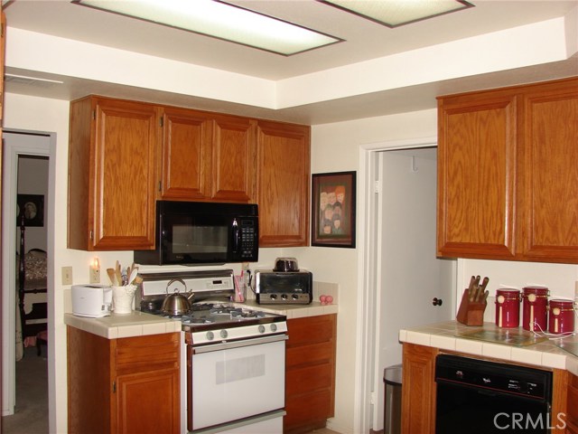 KITCHEN COOKING AREA HAS GAS STOVE, SPACE SAVER MICROWAVE AND COUNTER SPACE FOR TOASTER AND TOASTER OVEN. DOOR ON RIGHT IS OPENING TO INTERIOR LAUDRY ROOM.