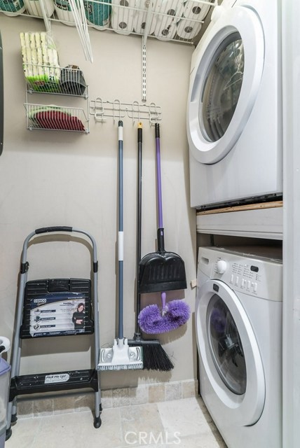 New separate laundry room and pantry with stacked washer dryer and adjustable shelving.