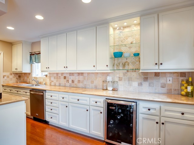 Kitchen has gorgeous cabinets and slab travertine countertops with tumbled travertine backsplash.