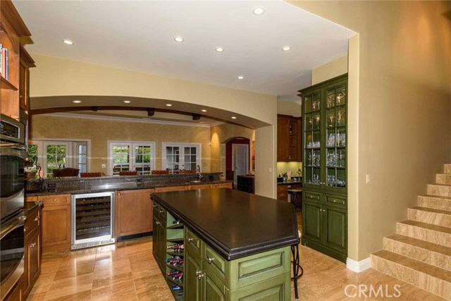 Kitchen features island with wine rack, wine and beverage cooler, and stylish built in cabinetry.