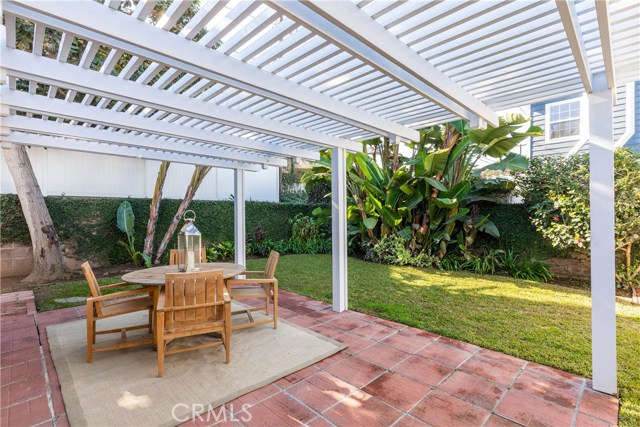 The lush and tranquil backyard with patio and pergola.