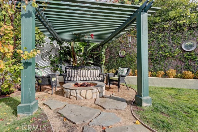 Pergola with fire pit in back yard