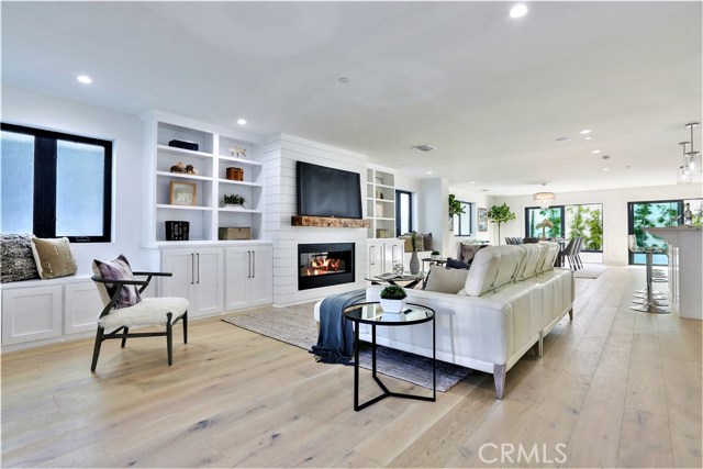 The Great Room, Open Concept Space has a Living Room, Dining Room, Entertainment Bar and a Spacious Gourmet Chef's Kitchen. The Living Room Features a Wall of Cabinets, a Wide Horizontal Fireplace, Window Seats and Ship Lap Siding. There is Recessed Can Lighting with Bright High Kelvin Daylight Lighting throughout the entire home.