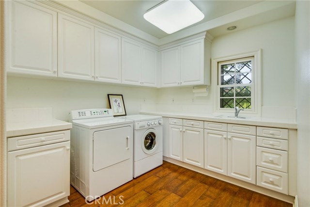 Large laundry room with sink and plenty or storage and counter space.