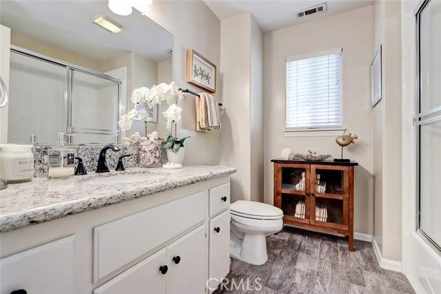 Guest bathroom with combo shower/tub, tile floors and granite countertops.