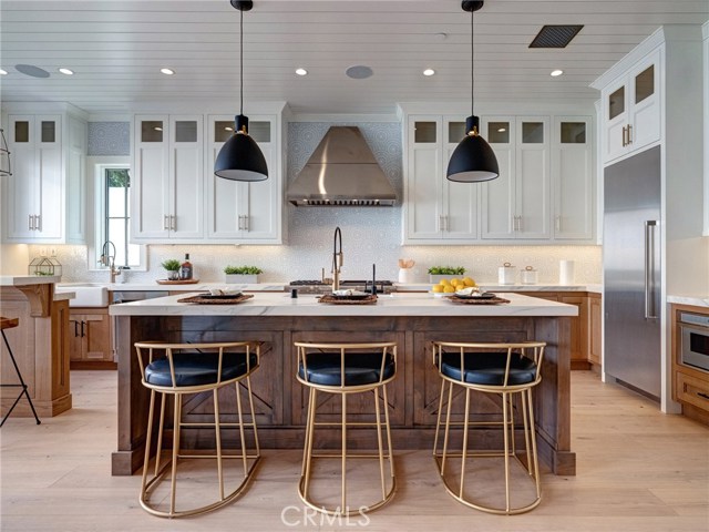 Neolith stone counters, Thermador professional series appliances, dual sinks, additional beverage fridge, Brizo faucets, breakfast counter, indoor/outdoor bar & entertainment area.