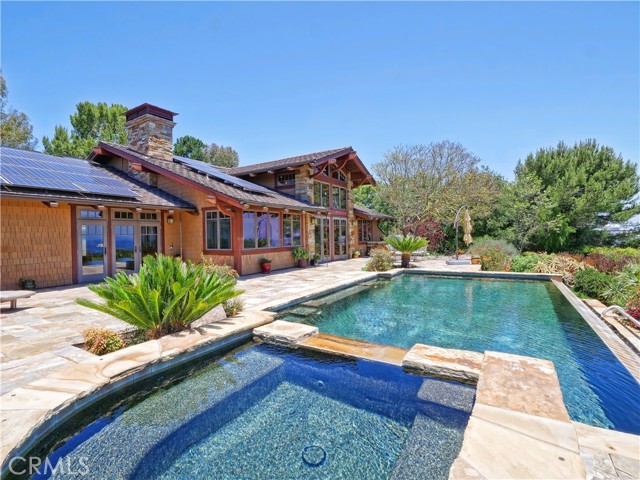 Rear pool and family sized spa from expansive stone-covered terrace.