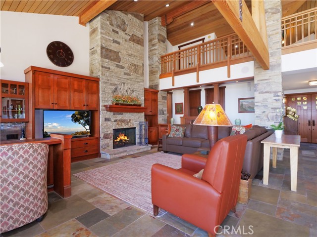 Family Room area of Great Room with stacked stone fireplace.  Loft on upper level.