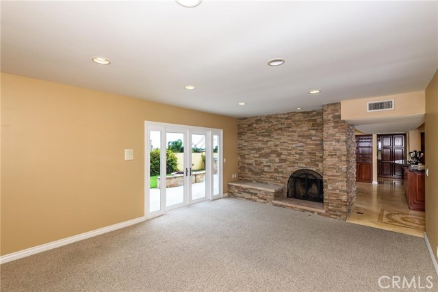 Living room with stacked stone fireplace that opens to a great back yard.