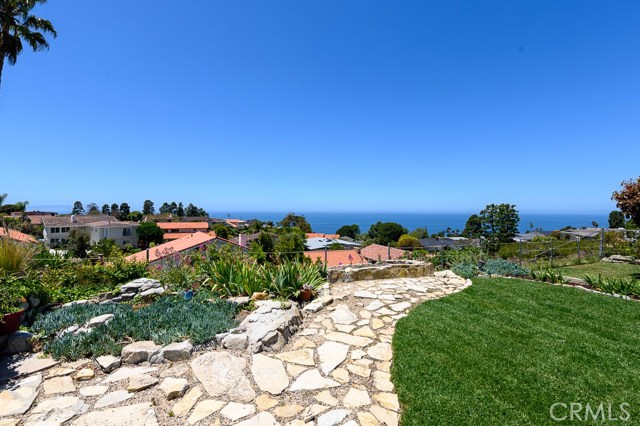 Grassy lawn and stone pavers, backyard oasis.