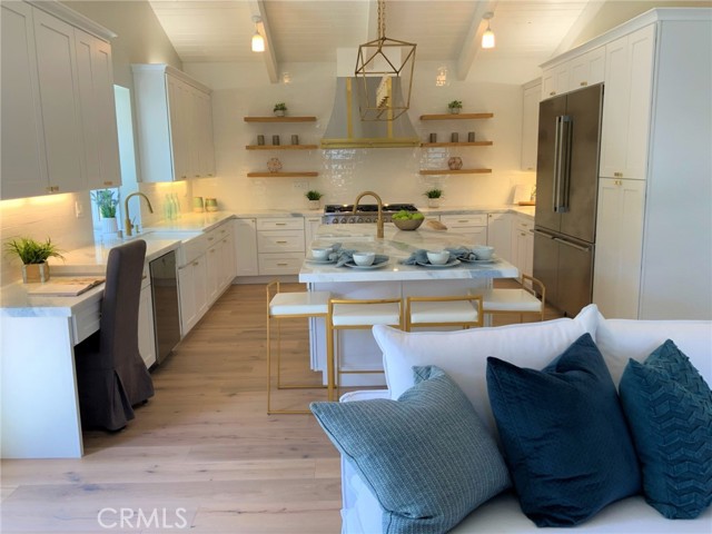 For a large family, gourmet cook or entertaining, look at the custom canopy hood, elegant tile detail surrounding the oven wall, tung and groove wood pitched ceiling with exposed beams, two refrigerators and freezers and loads of cabinets