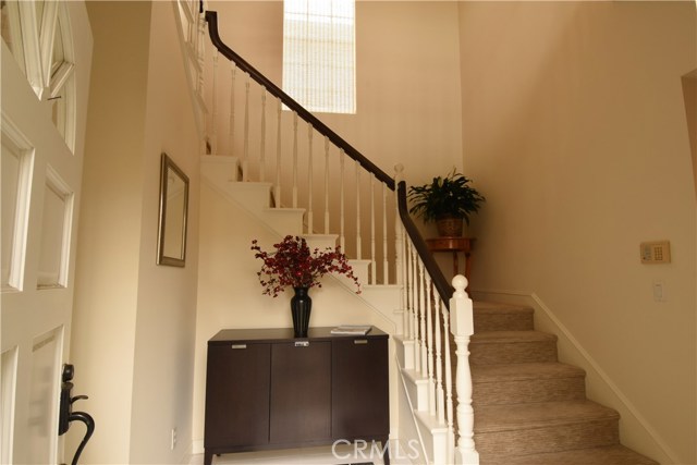 entrance with tall ceilings and stairwell to the 4 upstairs bedrooms.  Direct entrance to the garage is to the left of the open door.