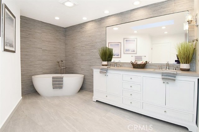 Beautifully remodeled master bathroom with a free-standing bath tub and a large shower stall on the other side