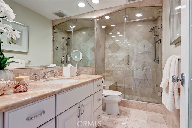 A spacious bathroom off the upper level hallway includes a large steam shower with built-in bench and beautiful travertine tile.