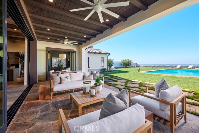 Covered patio and stacked sliding doors leading out to backyard with a spectacular view. Model home shown.