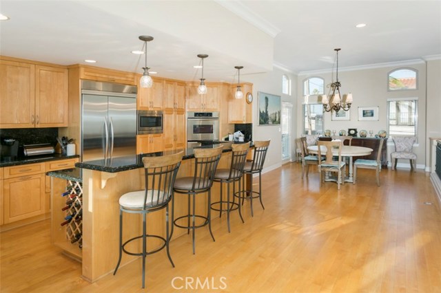 Chefs kitchen with breakfast bar with seating and dining room area