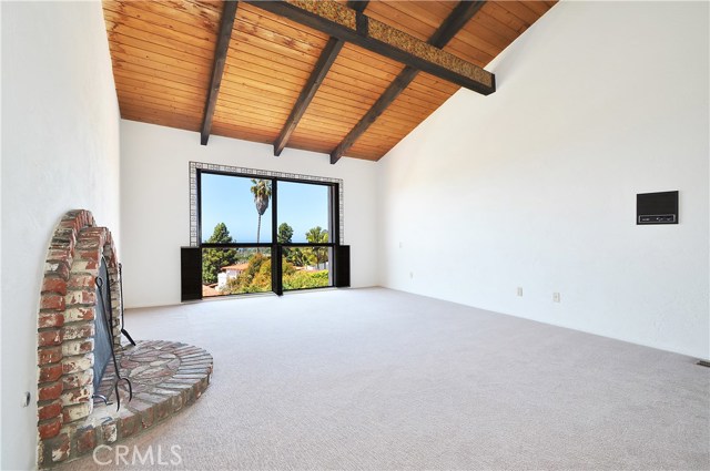 Large master bedroom with ocean view, fireplace, and vaulted ceilings