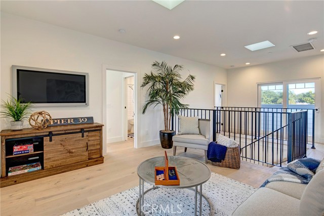 Upstairs family room with area with skylights, connecting two balconies, the master bedroom and two additional bedrooms, each with their own bathroom.