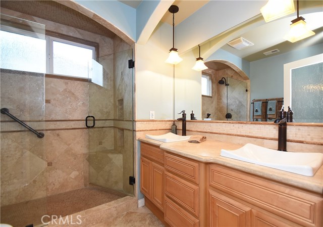 Dual master sinks and spacious travertine shower