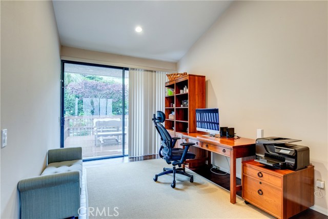 This bedroom, is currently being utilized as a functional home office and features a private patio