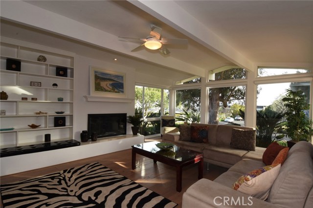 Living room is large & offers peaceful ocean view, pretty seating hearth, and lovely built-in shelving unit.