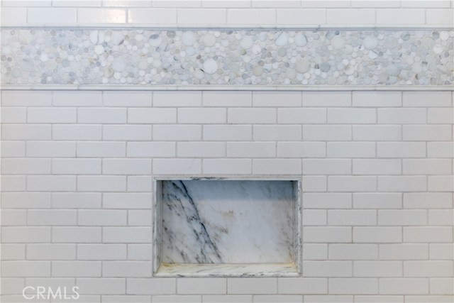 The hallway bathroom has been adorned with Walker Zanger Studio Moderne Stone: Calacatta Paramount Mosaic,
Walker Zanger Field Subway tile, Bath Fittings: Kohler Purist, Calacatta stone tile flooring, Lutron dimmer light switches.