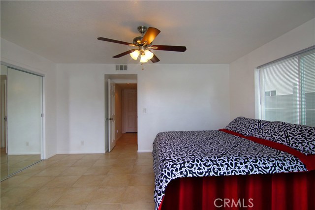 Fourth bedroom includes ceiling fan and over-sized closet with mirrored doors.