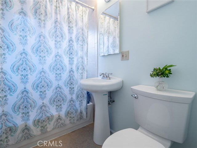 Full bathroom with bathtub / shower combination, pedestal sink, tile floors.