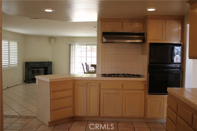 Cooking area in kitchen, range, oven and microwave.  Counter on left of range can accommodate bar stools.  Overlooks den and patio