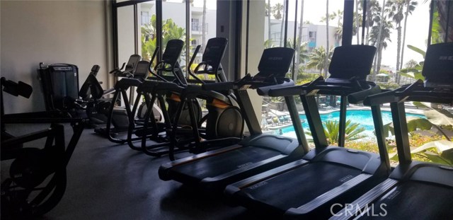 THE CARDIO PORTION OF THE VERY LARGE GYM OVERLOOKING THE POOL AND PACIFIC OCEAN