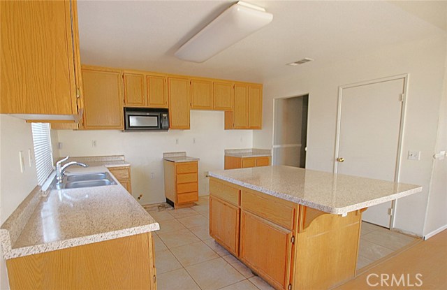 Spacious Kitchen with Stainless Steel Appliances, Tile Flooring, Built-in Microwave, Enclosed Pantry and More.