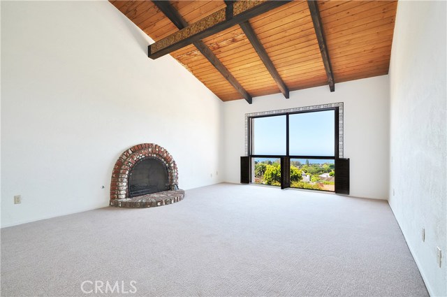 Large master bedroom with ocean view, fireplace, and vaulted ceilings