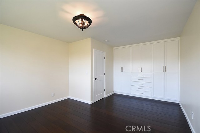 Bedroom features new real wood floors, new custom closet, new light, new windows and doors and hardware